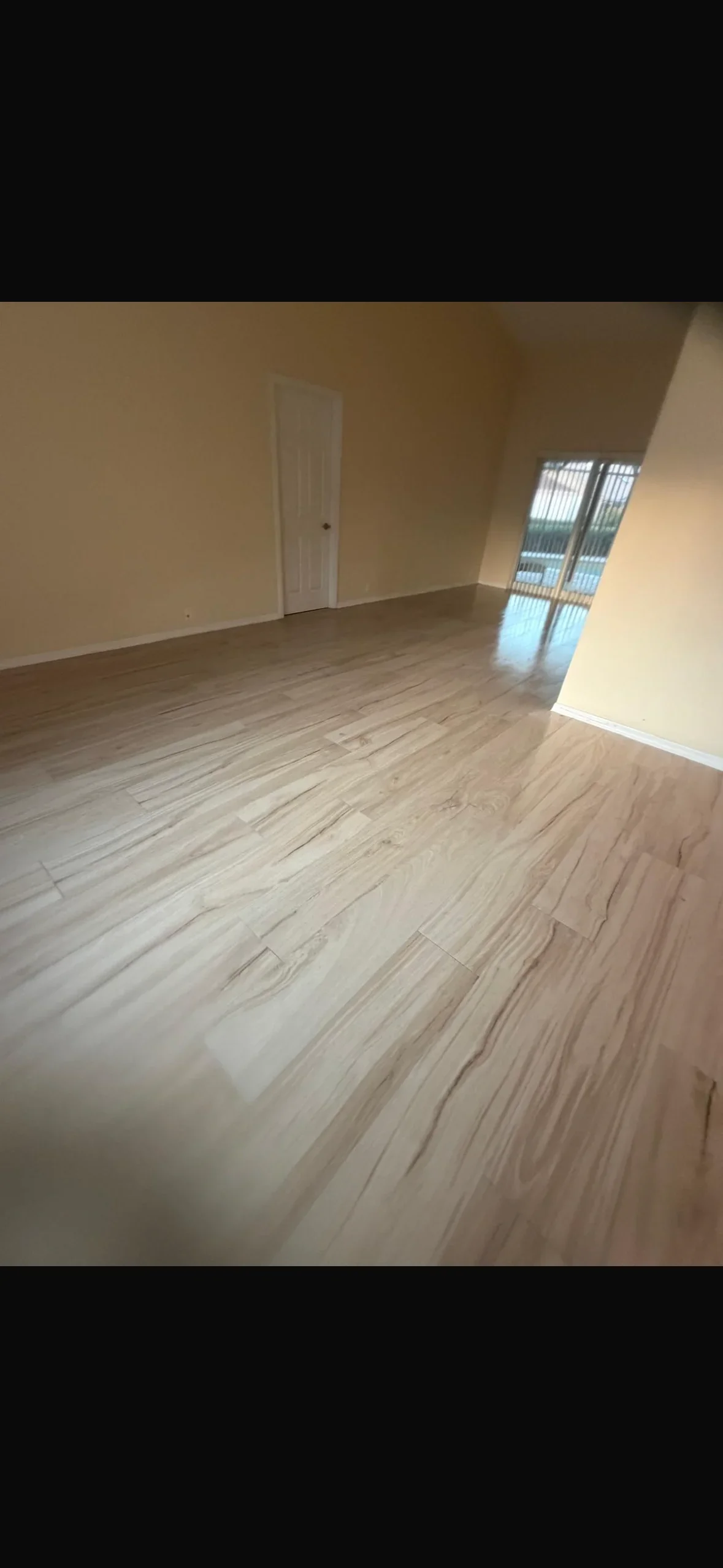 Light wood-look porcelain tile flooring with natural grain pattern in open room