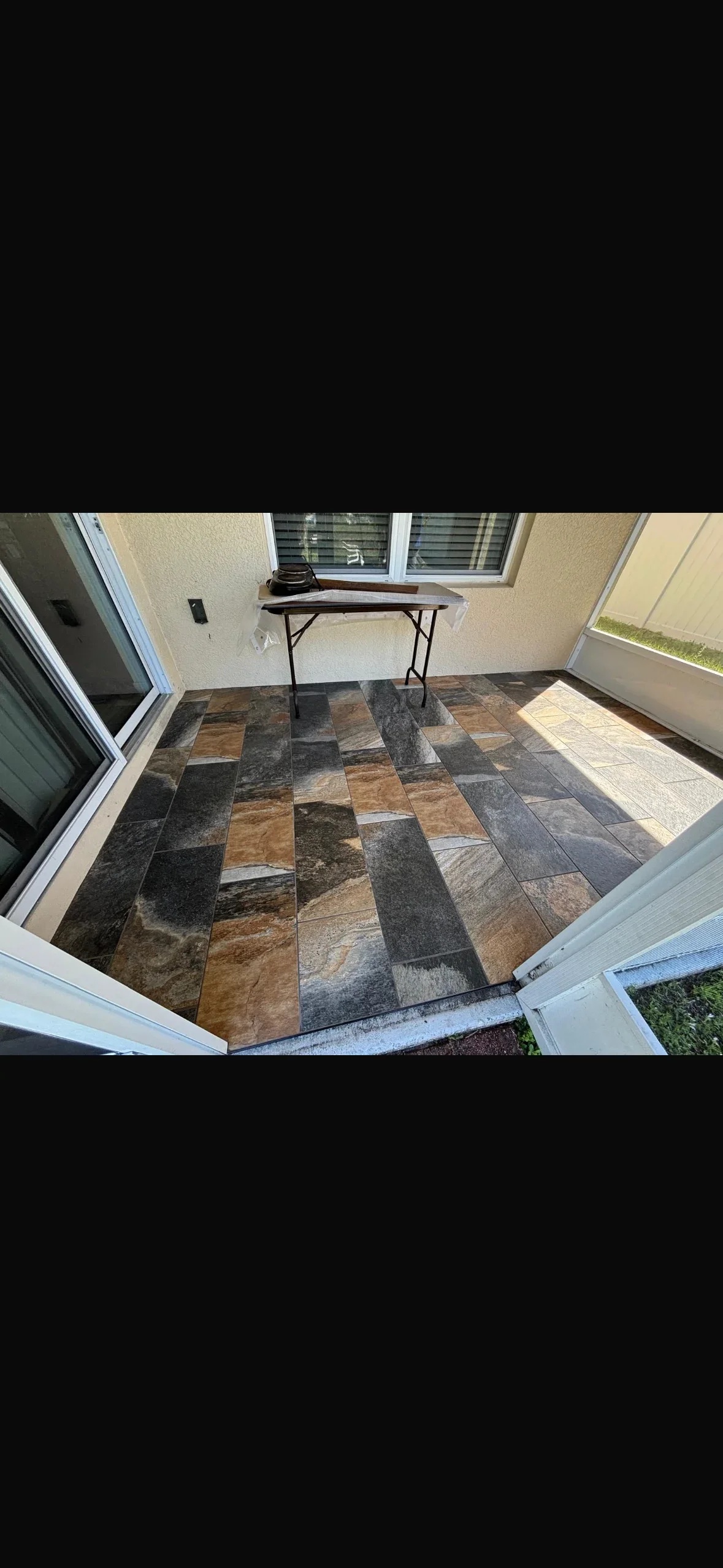 Mixed stone tile patio with geometric pattern in brown, gray, and charcoal tones