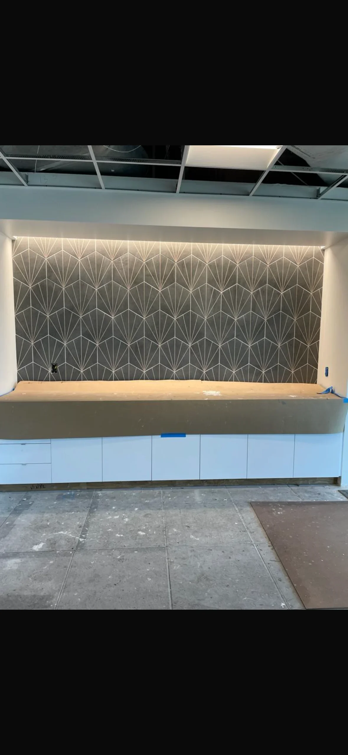 Geometric patterned tile feature wall with LED lighting and white subway tile base