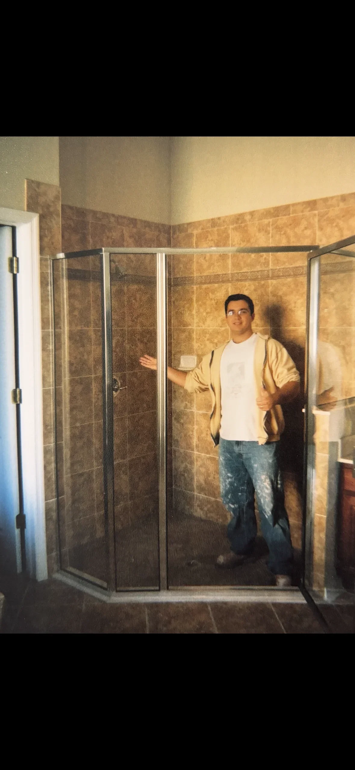 Ceramic tile shower with glass enclosure, warm brown porcelain tiles, chrome framing