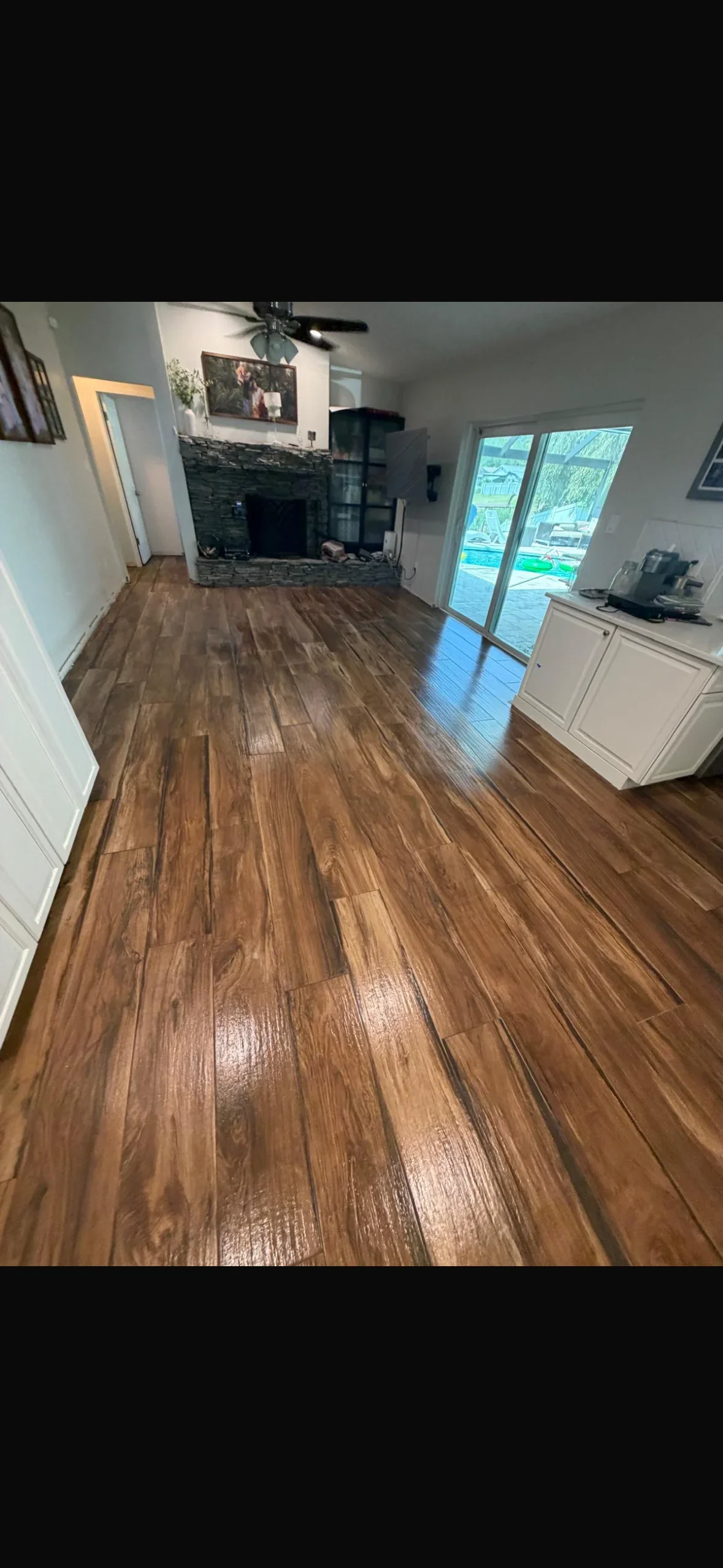 Luxury vinyl plank flooring with wood-grain texture installed in open living room and kitchen area