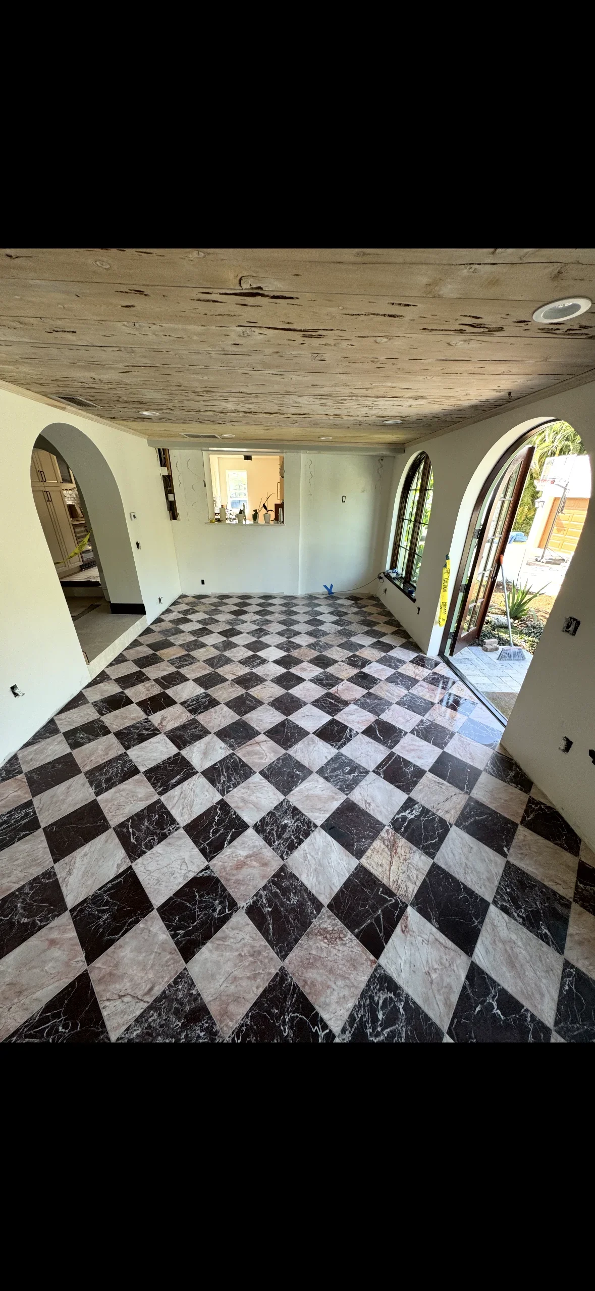 Black and white marble checkerboard tile floor with diagonal pattern in room with arched doorways