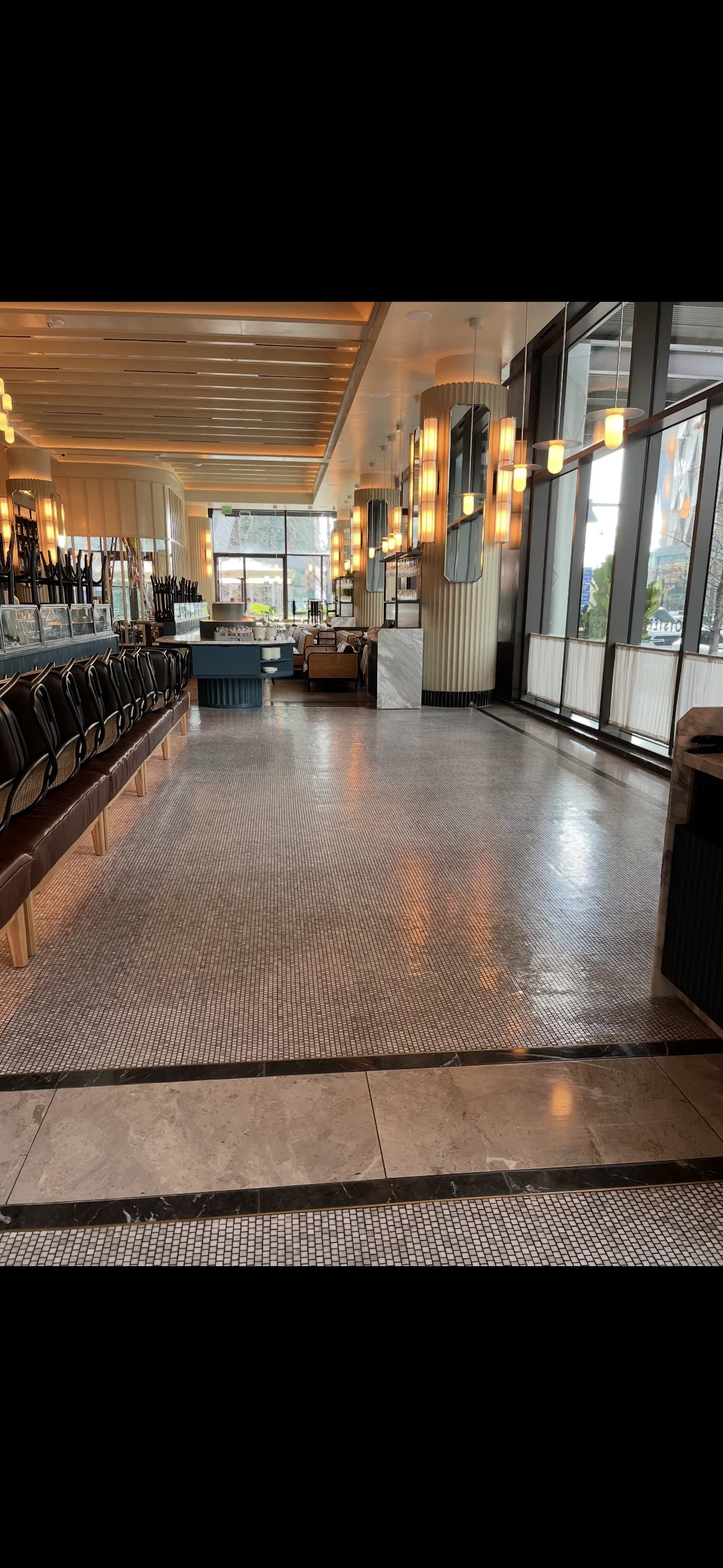 Textured tile flooring with stone thresholds in commercial showroom space