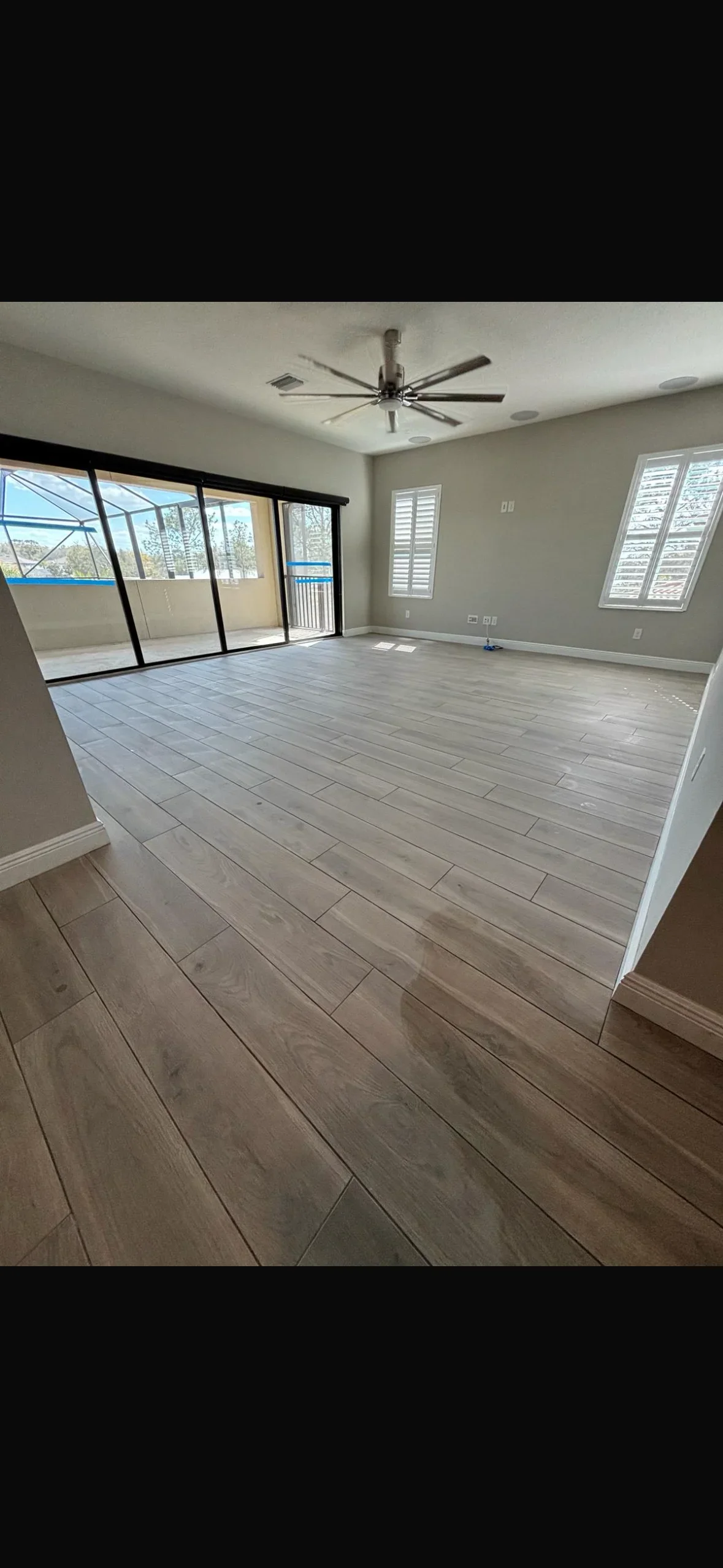 Large format wood-look plank tile flooring in gray and brown tones installed in open living space